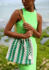 Colette macrame tote bag in Green and White. When Tenniscore meets Beachcore. Ideal for beach holidays, COLETTE has been hand-woven from a durable cotton rope with flattering chain straps and tasseled ties. It’s just the perfect to store all your beach essentials for a carefree island getaway. Wear yours with matching separates for an effortless beach look.