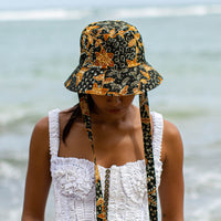 The Jasmine hat in Black and brown  is made meticulously of handpainted Batik fabric into a bucket silhouette with a medium dome-down brim to keep you under the shade during summer’s hottest days.  Made with light yet structural shape, the Jasmine hat is made to be your summer vacation essential. &nbsp;It has a packable design that makes it perfect for travel or storing in your beach bag.