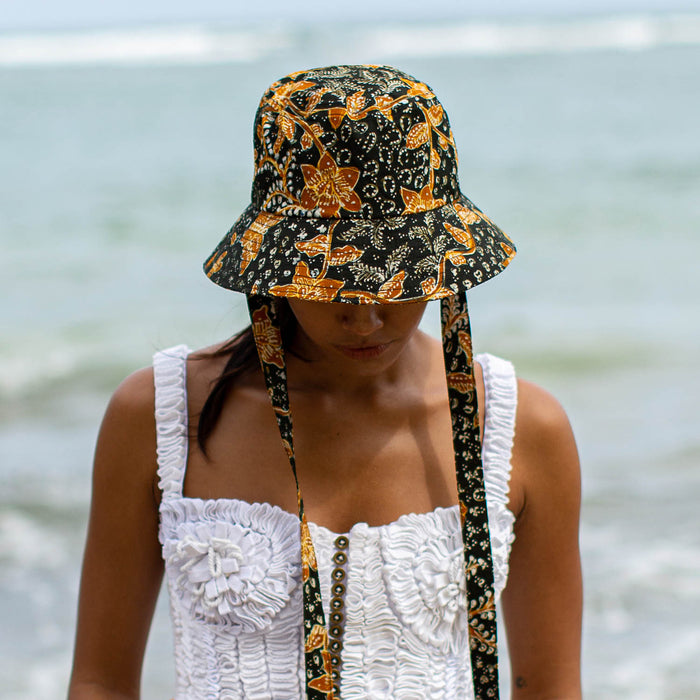The Jasmine hat in Black and brown  is made meticulously of handpainted Batik fabric into a bucket silhouette with a medium dome-down brim to keep you under the shade during summer’s hottest days.  Made with light yet structural shape, the Jasmine hat is made to be your summer vacation essential. &nbsp;It has a packable design that makes it perfect for travel or storing in your beach bag.