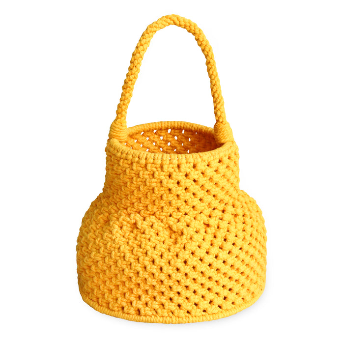 Olga is strolling by the shore with BrunnaCo's Petite Naga Macrame Beach Bag in Butter Yellow — the perfect companion for a sun-kissed summer day.