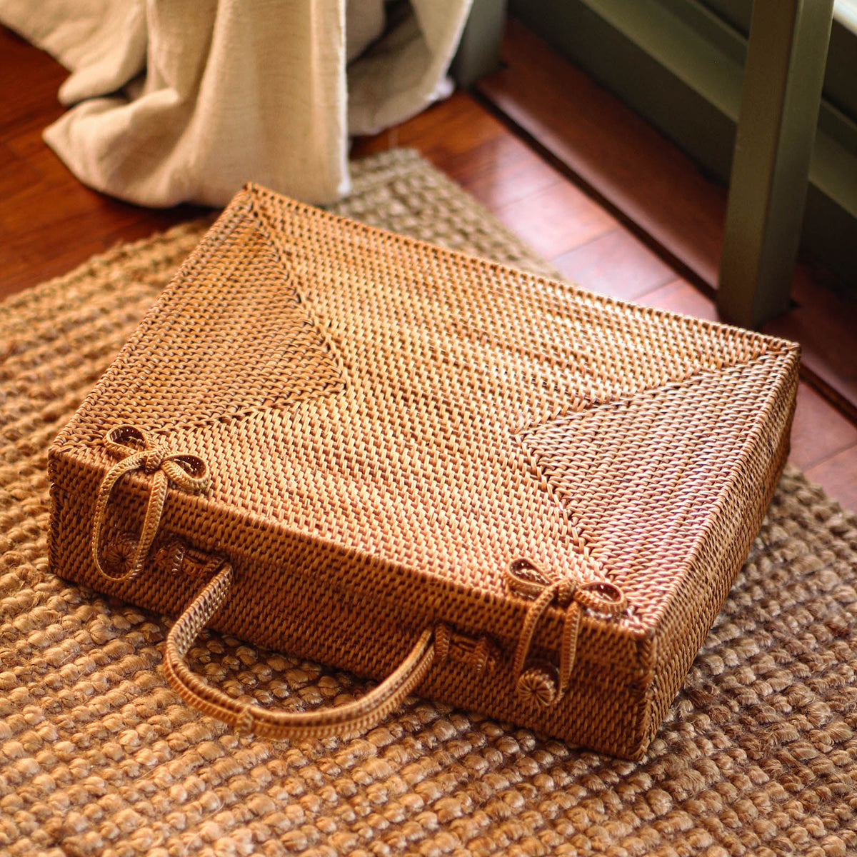 Inka Williams is holding BrunnaCo's Rahayu Atta Rattan Bag handmade in Bali using natural Atta rattan straws from Lombok. Inka is wearing BrunnaCo's Srikandi Ruffle Christmas dress in Sienna Brown. Designed in California.