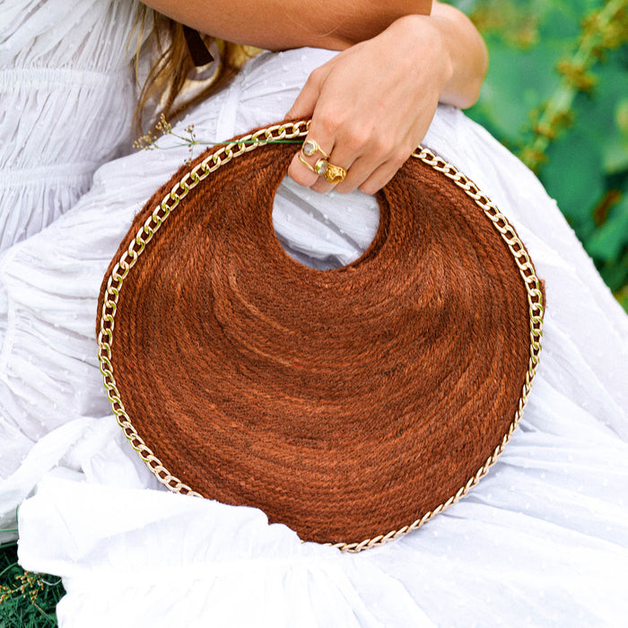 Inka Williams effortlessly styles BrunnaCo's Brown Solo Espresso Mini Round Jute Bag, accented with gold-chain details, in a sun-drenched Bali photoshoot. Handcrafted in Bali with a hint of Californian flair, the Solo Round Bag embodies timeless elegance and artisanal charm.