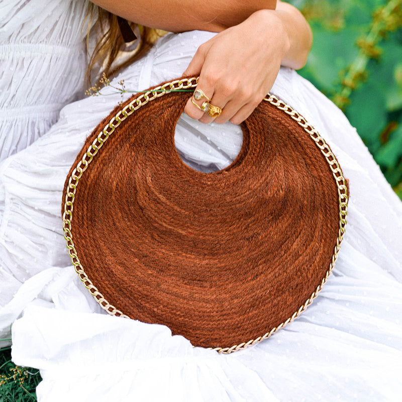 Inka Williams effortlessly styles BrunnaCo's Brown Solo Espresso Mini Round Jute Bag, accented with gold-chain details, in a sun-drenched Bali photoshoot. Handcrafted in Bali with a hint of Californian flair, the Solo Round Bag embodies timeless elegance and artisanal charm.