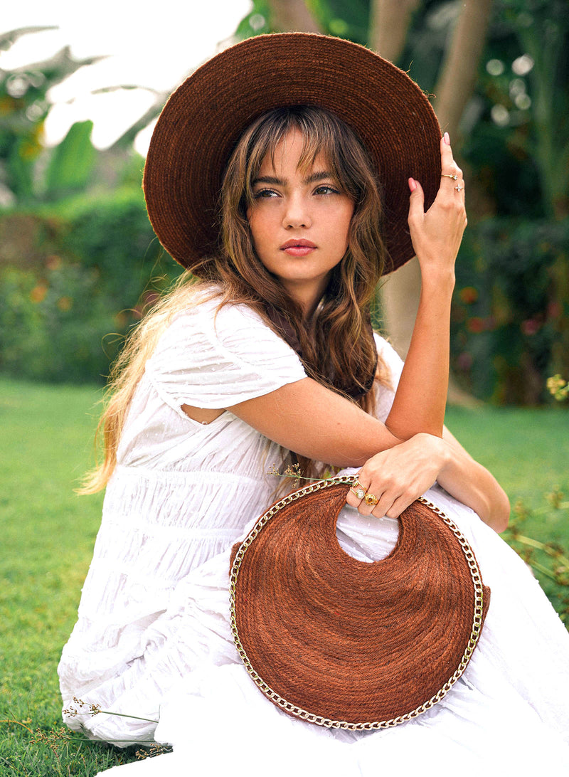 Inka Williams effortlessly styles BrunnaCo's Brown Solo Espresso Mini Round Jute Bag, accented with gold-chain details, in a sun-drenched Bali photoshoot. Handcrafted in Bali with a hint of Californian flair, the Solo Round Bag embodies timeless elegance and artisanal charm.