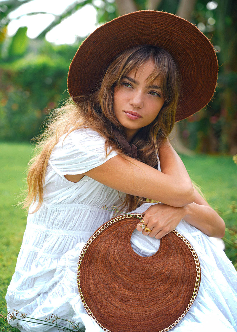 Inka Williams effortlessly styles BrunnaCo's Brown Solo Espresso Mini Round Jute Bag, accented with gold-chain details, in a sun-drenched Bali photoshoot. Handcrafted in Bali with a hint of Californian flair, the Solo Round Bag embodies timeless elegance and artisanal charm.