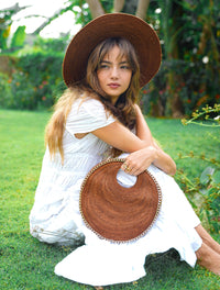 Inka Williams effortlessly styles BrunnaCo's Brown Solo Espresso Mini Round Jute Bag, accented with gold-chain details, in a sun-drenched Bali photoshoot. Handcrafted in Bali with a hint of Californian flair, the Solo Round Bag embodies timeless elegance and artisanal charm.
