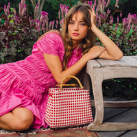 Inka Williams is wearing BrunnaCo's Srikandi Ruffle Dress in Pink Color, styled with Recycled Plastic TUKU Bag that are handmade by artisans in Bali, with a touch of Californian flair
