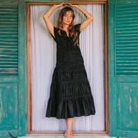Inka Williams is wearing BrunnaCo's Black Srikandi Ruffle Dress styled with the Black Solo Jute Bag in a photoshoot in Bali. The dress is handmade by artisans in Bali, designed with Californian flair.