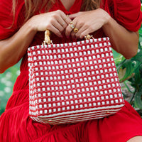 Inka Williams carries BrunnaCo's TUKU Recycled Plastic Market Tote, a handcrafted piece from Java and Bali made from repurposed plastic waste. Designed in California, it embodies the effortless charm of a California farmers' market.