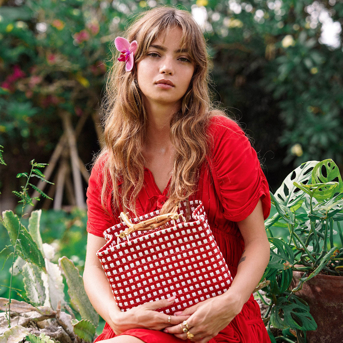 Inka Williams carries BrunnaCo's TUKU Recycled Plastic Market Tote, a handcrafted piece from Java and Bali made from repurposed plastic waste. Designed in California, it embodies the effortless charm of a California farmers' market.