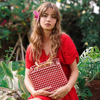 Inka Williams carries BrunnaCo's TUKU Recycled Plastic Market Tote, a handcrafted piece from Java and Bali made from repurposed plastic waste. Designed in California, it embodies the effortless charm of a California farmers' market.