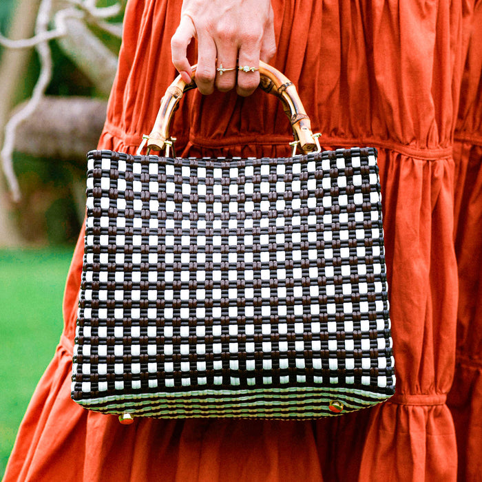 Inka Williams carries BrunnaCo’s **TUKU Recycled Tote Bag** in black and white—a handcrafted market tote, ethically made by artisans in Bali and designed in California with a signature coastal touch.