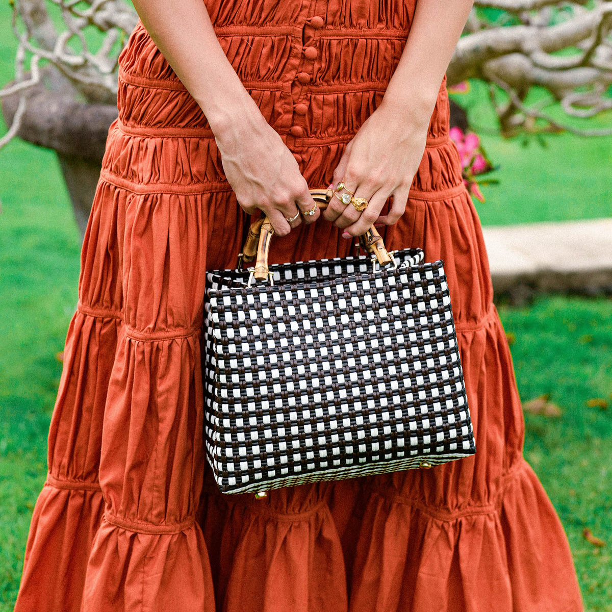 Inka Williams carries BrunnaCo’s **TUKU Recycled Tote Bag** in black and white—a handcrafted market tote, ethically made by artisans in Bali and designed in California with a signature coastal touch.