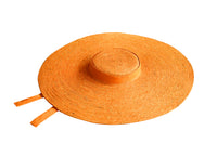 LOLA Wide Brim Jute Straw Hat In Orange. Braided meticulously by artisans in Gianyar, Bali from natural Jute material, this sweet hat offers both comfort and elegance. Designed with ideal thickness and weight that allow its brim to be easily folded, stretched, and styled, making it easy to take to any holiday trips or summer vacation.