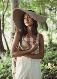 Lola Wide Brim Jute Straw Hat with Black Strap. Braided meticulously by artisans in Gianyar, Bali from natural Jute material, this sweet hat offers both comfort and elegance. Designed with ideal thickness and weight that allow its brim to be easily folded, stretched, and styled, making it easy to take to any holiday trips.