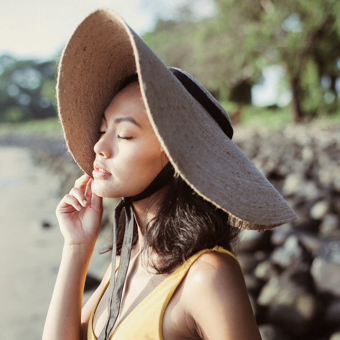 Lola Wide Brim Jute Straw Hat with Black Strap. Braided meticulously by artisans in Gianyar, Bali from natural Jute material, this sweet hat offers both comfort and elegance. Designed with ideal thickness and weight that allow its brim to be easily folded, stretched, and styled, making it easy to take to any holiday trips.