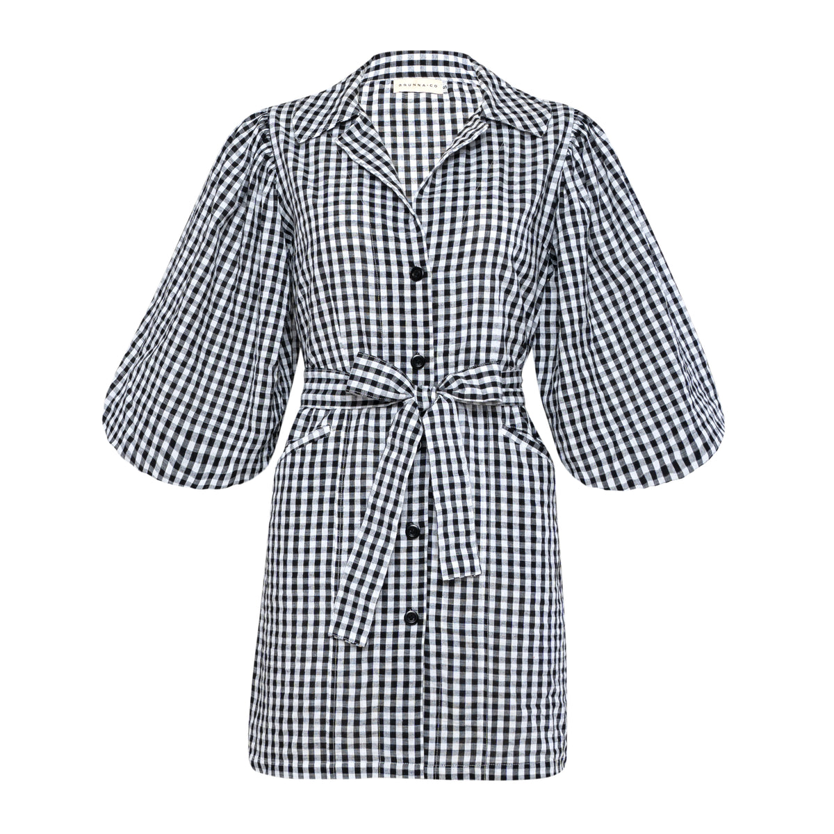 BrunnaCo Meghan Mini Gingham Dress in Black - A stylish and versatile dress made from 100% cotton. This dress features a sweet silhouette with voluminous medium-length puff sleeves, a chic short skirt with bow-detailing, and a removable waist belt. The Meghan Mini Gingham Dress is perfect for any occasion, from a casual picnic to a formal event.