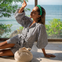 BrunnaCo Meghan Mini Gingham Dress in Black - A stylish and versatile dress made from 100% cotton. This dress features a sweet silhouette with voluminous medium-length puff sleeves, a chic short skirt with bow-detailing, and a removable waist belt. The Meghan Mini Gingham Dress is perfect for any occasion, from a casual picnic to a formal event.
