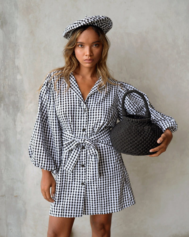 BrunnaCo Meghan Mini Gingham Dress in Black - A stylish and versatile dress made from 100% cotton. This dress features a sweet silhouette with voluminous medium-length puff sleeves, a chic short skirt with bow-detailing, and a removable waist belt. The Meghan Mini Gingham Dress is perfect for any occasion, from a casual picnic to a formal event.