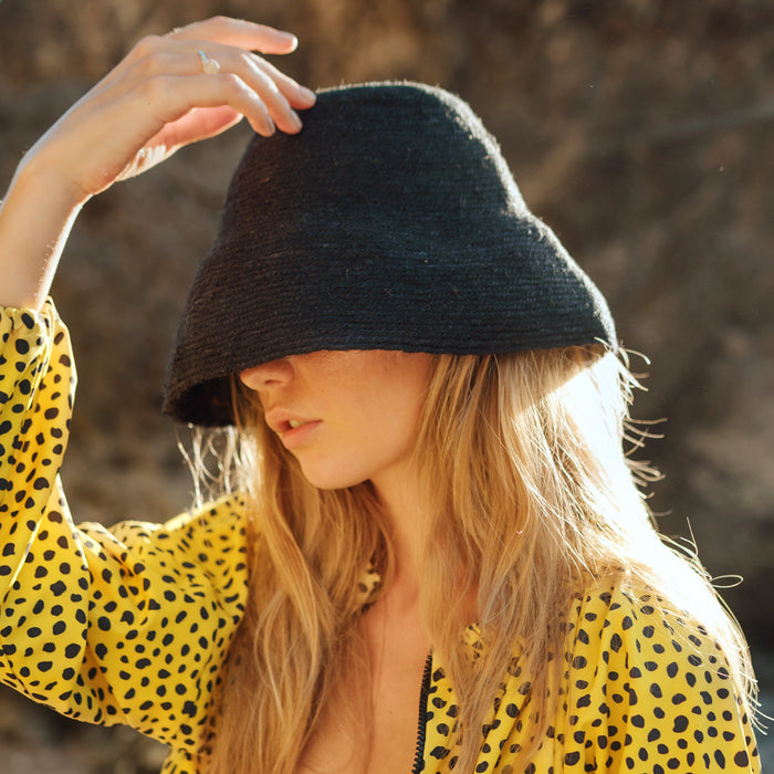 Naomi Jute Bucket Hat in black is designed specifically for the wild at heart with classic sophistication. Enjoy lounging poolside or exploring the city on sun-soaked days as its protective hat brim provides ample shade. Made of natural jute straws which have the perfect weight, this hat will sit comfortably and won't fly away in sudden gusts. It's also very practical to pack in any size luggages and ideal to take on any trips.