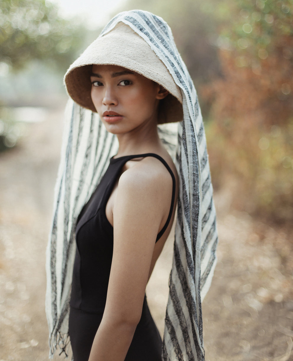 Naomi Jute Straw hat in Beige. Naomi Jute Bucket Hat is designed specifically for the wild at heart with classic sophistication. Enjoy lounging poolside or exploring the city on sun-soaked days as its protective hat brim provides ample shade. Made of natural jute straws which have the perfect weight, this hat will sit comfortably and won't fly away in sudden gusts. It's also very practical to pack in any size luggages and ideal to take on any trips.