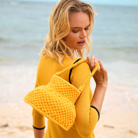 Olga is strolling by the shore with BrunnaCo's Petite Naga Macrame Beach Bag in Butter Yellow — the perfect companion for a sun-kissed summer day.