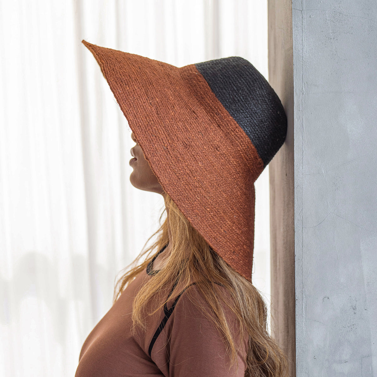 Duo color tone handwoven beach straw hat in Burnt Sienna and Black color, handmade from natural jute straw by local artisan in Bali. Handmade vacation wide-brim hat with domed down brim for maximum sun protection. Sustainably made by female artisan community in Indonesia.