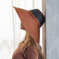 Duo color tone handwoven beach straw hat in Burnt Sienna and Black color, handmade from natural jute straw by local artisan in Bali. Handmade vacation wide-brim hat with domed down brim for maximum sun protection. Sustainably made by female artisan community in Indonesia.