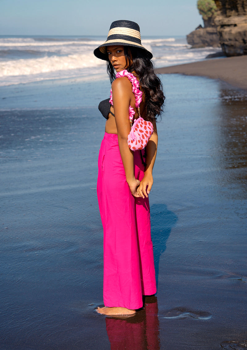 Taylor pants in hot barbie pink are a classic piece, made for a perfect day under the warm sun. Made with comfy and light-weight cotton fabric, these pleated pants have a high rise and slim fit along the waist with a wide-leg silhouette. Wear yours with BrunnaCo’s rope bralette or a cropped top.